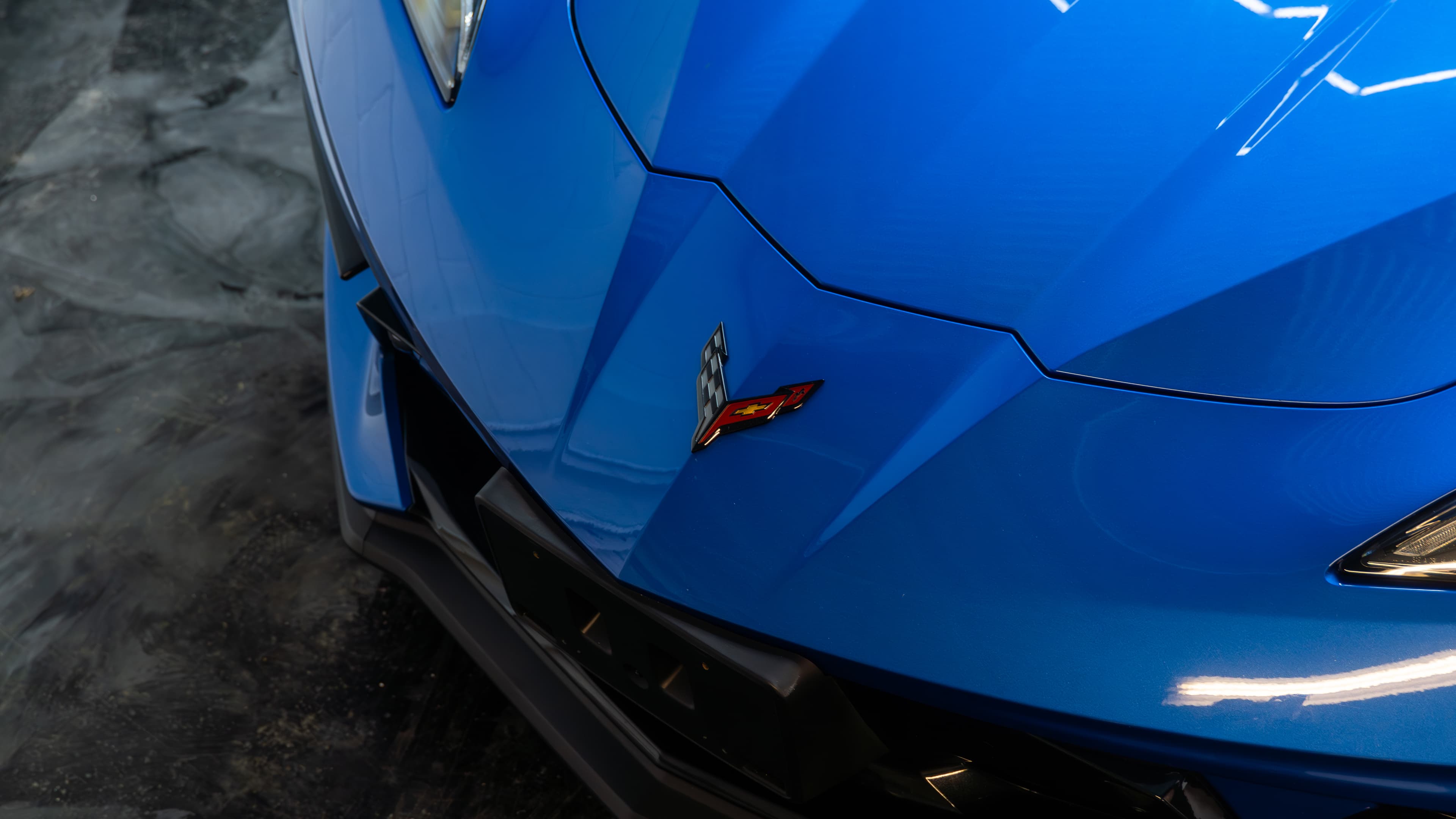 Close-up examination of paint detail on a Corvette under controlled lighting