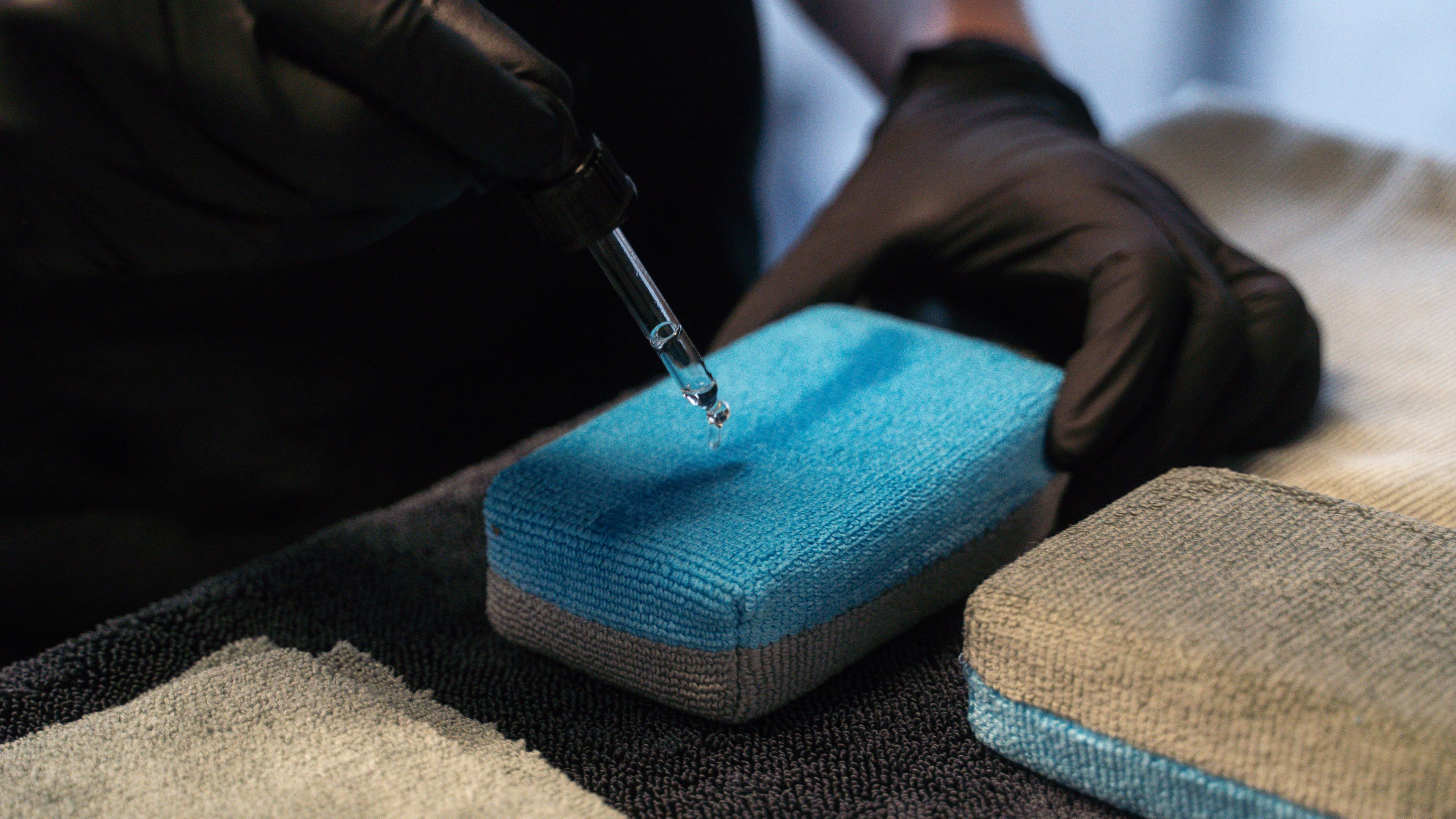 Ceramic coating being precisely applied from a syringe onto an applicator pad